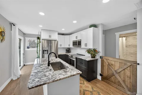 a kitchen with stainless steel appliances granite countertop sink stove and refrigerator