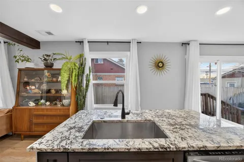 a bathroom with a granite countertop sink a mirror and shower