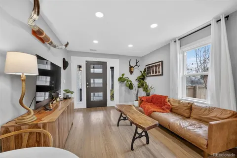 a living room with furniture and a wooden floor