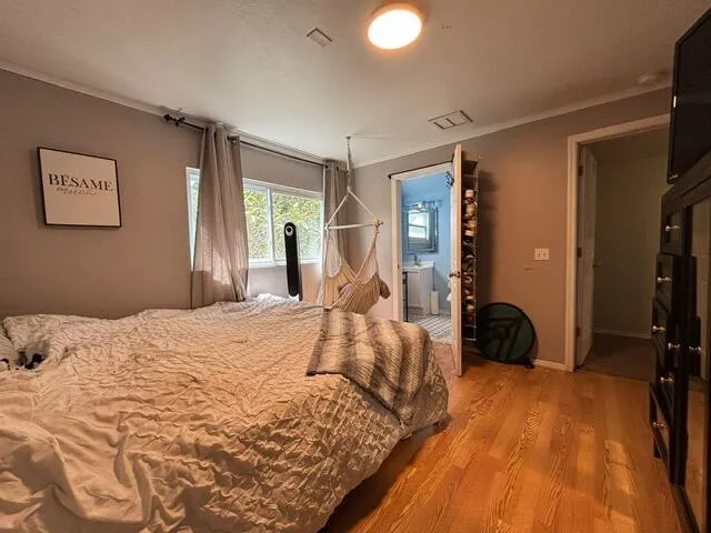 a bedroom with a bed and wooden floor