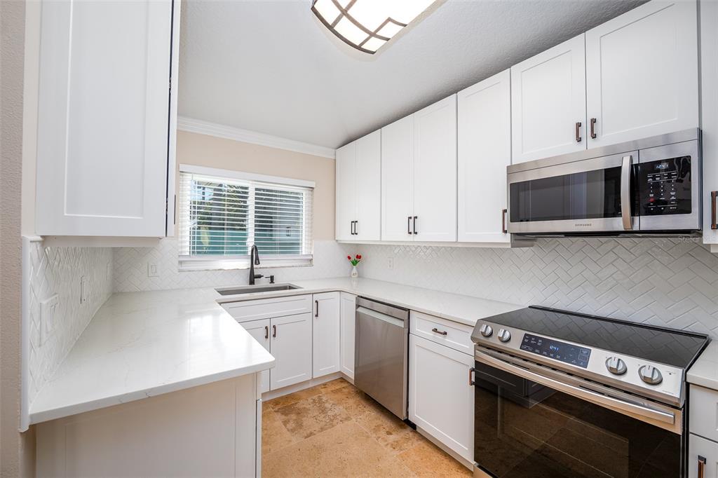 323 North 10th Street Flagler Beach, FL 32136 - Photo 11 of 45 a kitchen with a stove and a microwave