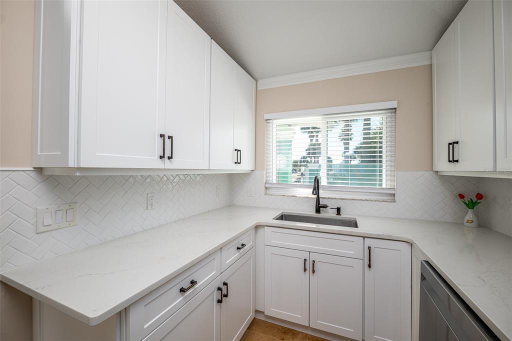 323 North 10th Street Flagler Beach, FL 32136 - Photo 12 of 45 a kitchen with white cabinets and window