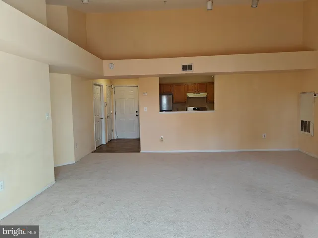 a view of a white house next to a yard with big trees