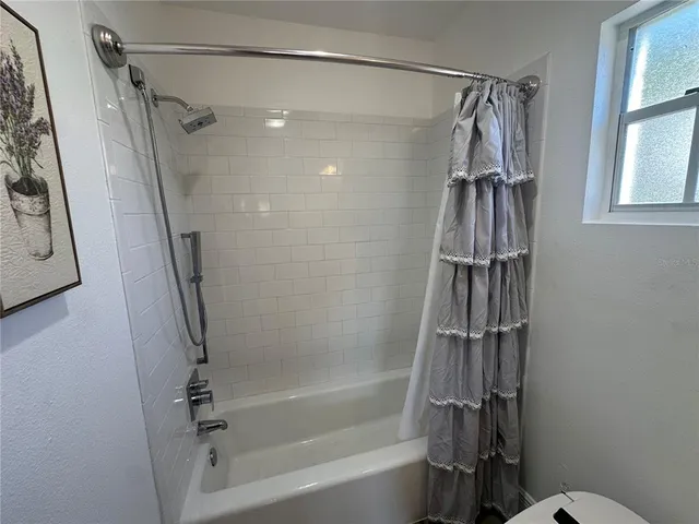 a bathroom with a shower and a glass door