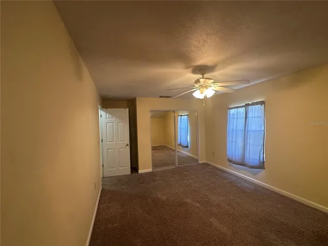 a view of an empty room with a ceiling fan