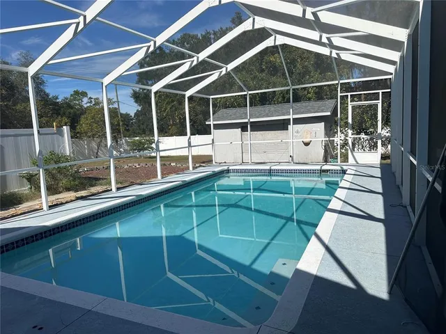 a view of a backyard with floor to ceiling window and wooden floor