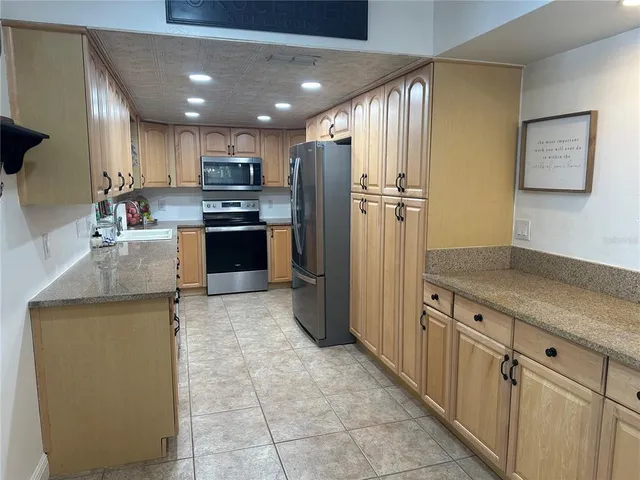 a kitchen with stainless steel appliances granite countertop a refrigerator and a sink