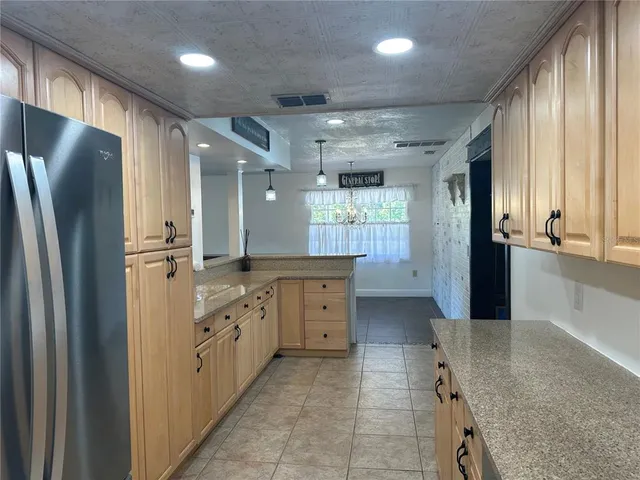 a kitchen with granite countertop a refrigerator and a sink