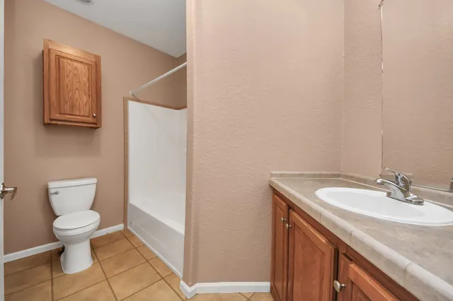 a bathroom with a granite countertop toilet and sink