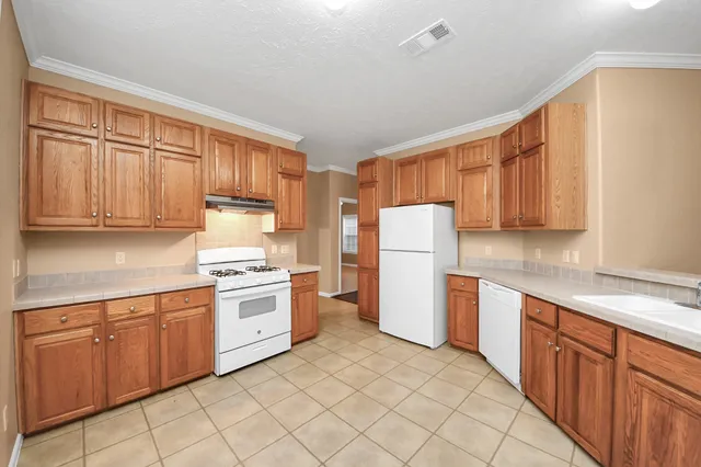 a kitchen with a sink a refrigerator and cabinets