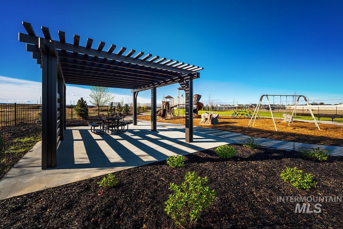 1700 East Hadler Street Meridian, ID 83642 - Photo 24 of 25 Expansive outdoor recreation area featuring a modern pergola with a built-in picnic table, a swing set, and a playground structure