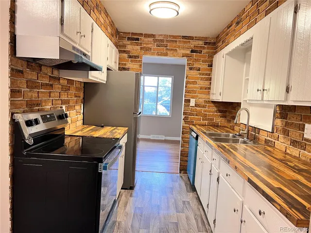 a kitchen with granite countertop a sink stove and cabinets