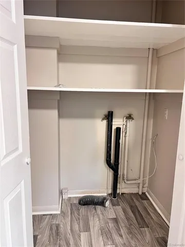 a view of a closet with wooden floor