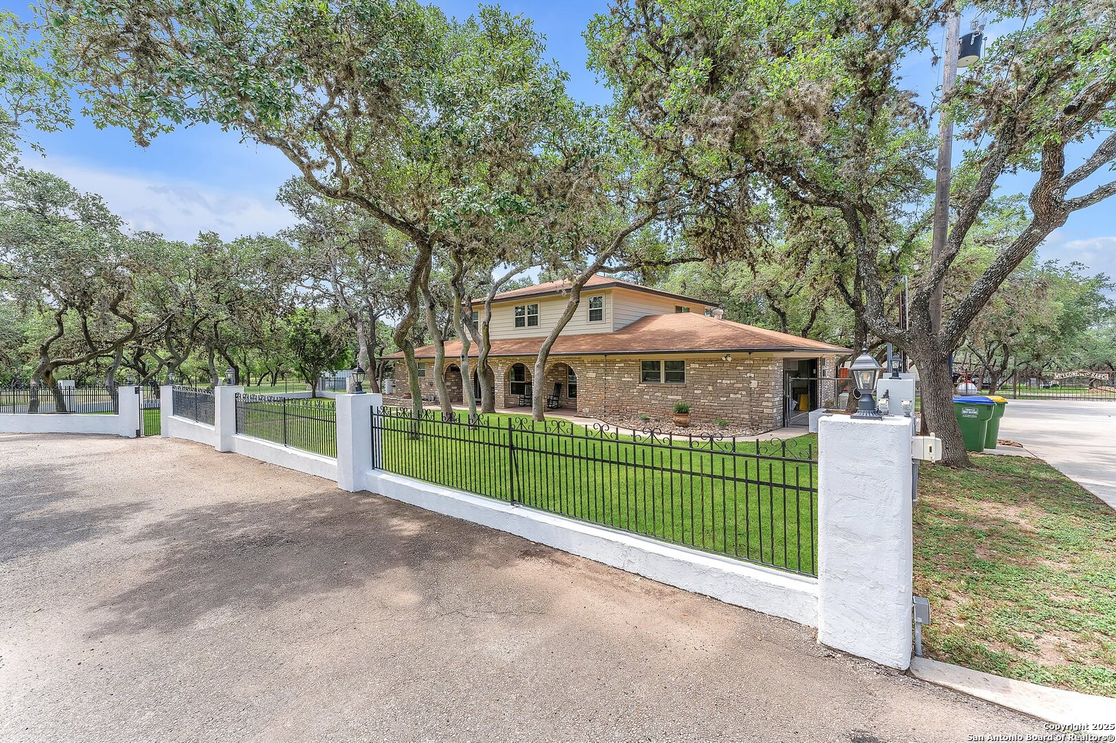 11650 Sunset Ranch Helotes, TX 78023 - Photo 135 of 141 a front view of a house with a garden and tree