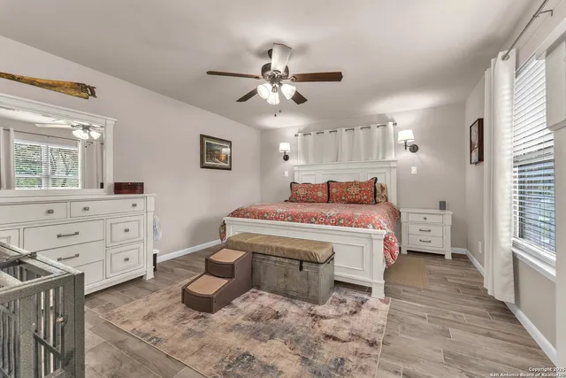 a living room with furniture a ceiling fan and a wooden floor