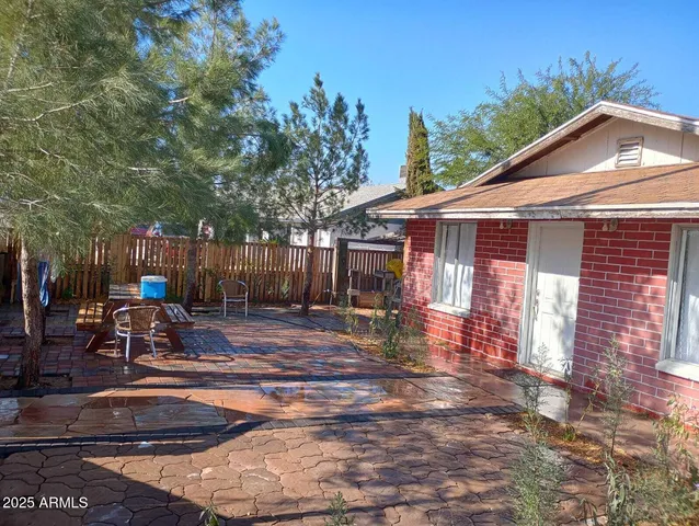 a view of a patio with table and chairs with wooden fence and plants