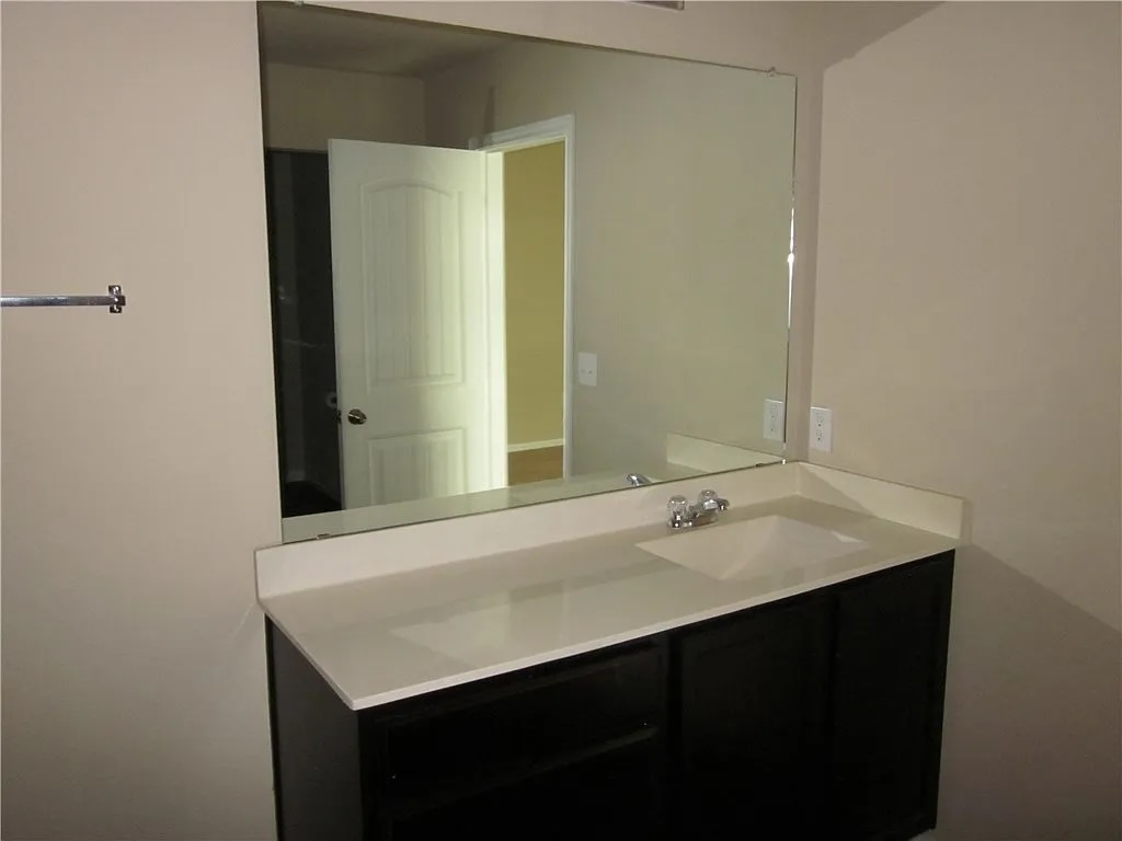 541 Alpha Kyle, TX 78640 - Photo 8 of 9 A sleek vanity with an integrated sink and reflective mirror offers both style and practicality.