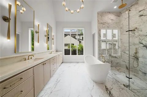 a large white bathroom with a large tub a sink and shower