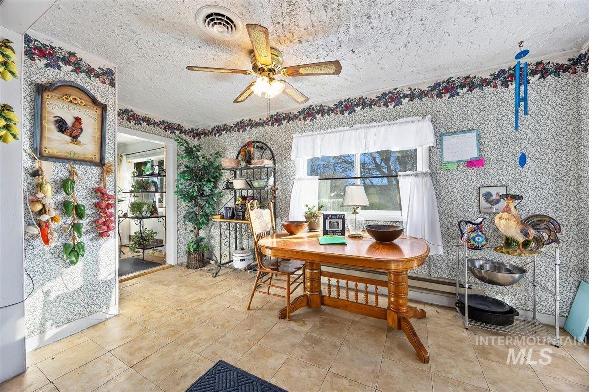 534 Miller Avenue Burley, ID 83318 - Photo 12 of 27 Dining room featuring wallpapered walls, a ceiling fan, a textured ceiling, and tile patterned floors