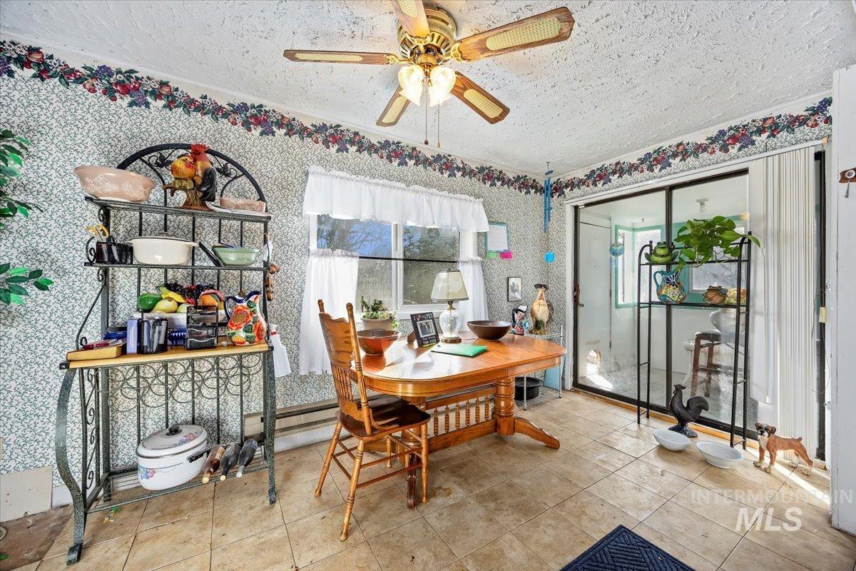 534 Miller Avenue Burley, ID 83318 - Photo 13 of 27 Dining area featuring wallpapered walls, ceiling fan, and a textured ceiling