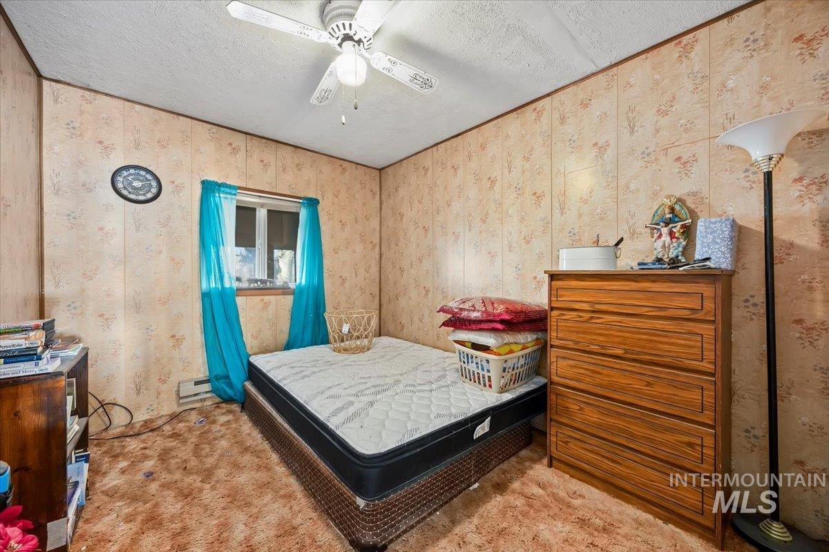 534 Miller Avenue Burley, ID 83318 - Photo 17 of 27 Carpeted bedroom featuring a textured ceiling, ceiling fan, and wallpapered walls