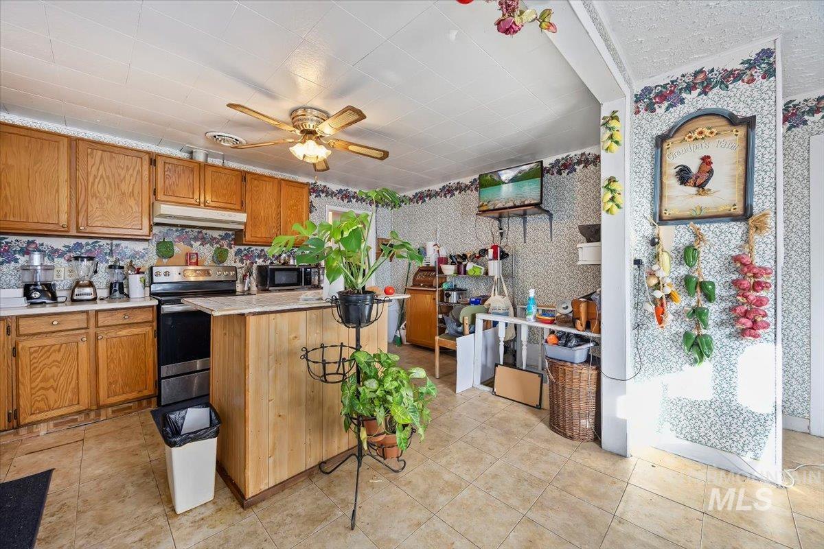 534 Miller Avenue Burley, ID 83318 - Photo 8 of 27 Kitchen with ceiling fan, wood finish cabinets, light countertops, stainless steel appliances, and wallpapered walls