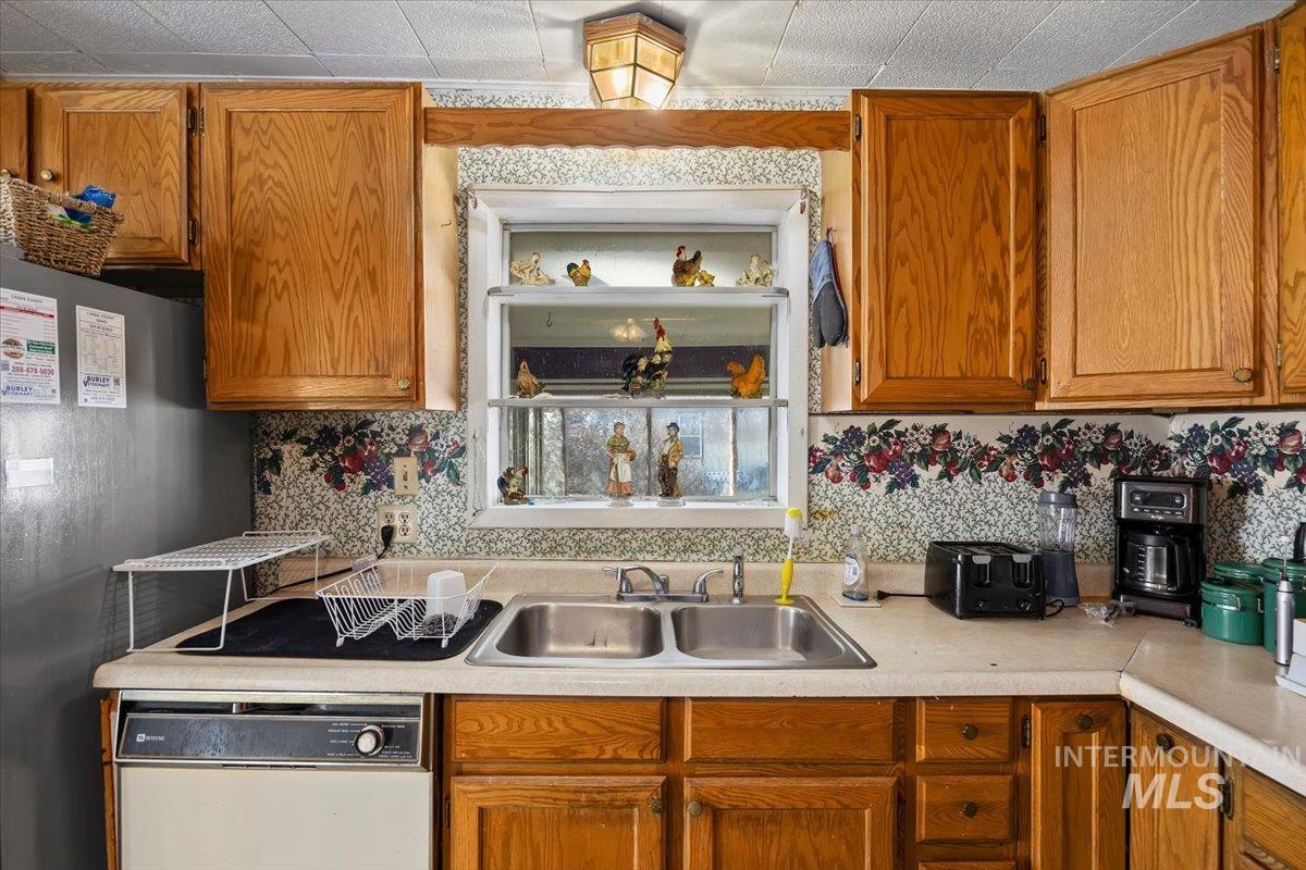 534 Miller Avenue Burley, ID 83318 - Photo 10 of 27 Kitchen featuring white dishwasher, freestanding refrigerator, light countertops, and wood finish cabinetry