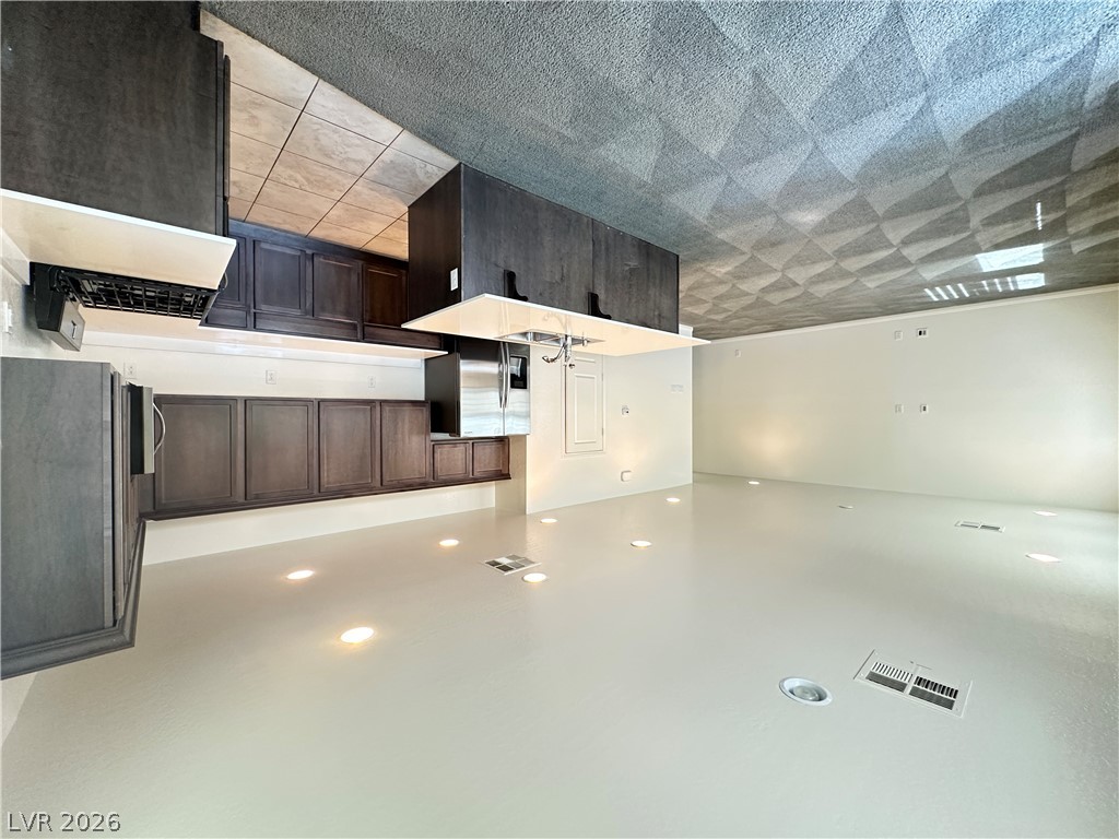 6784 Pivot Point Street Las Vegas, NV 89148 - Photo 5 of 27 A well-lit kitchen with dark cabinetry and ample counter space awaits culinary creativity.