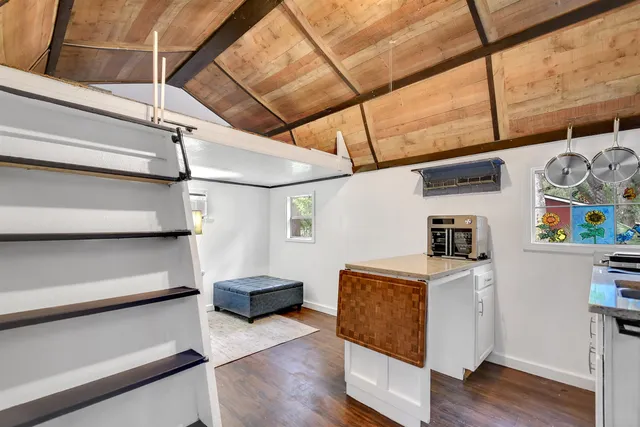 a view of a storage & utility room with fridge and wooden floor