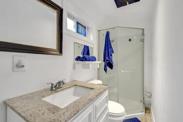 a bathroom with a granite countertop sink a mirror and vanity