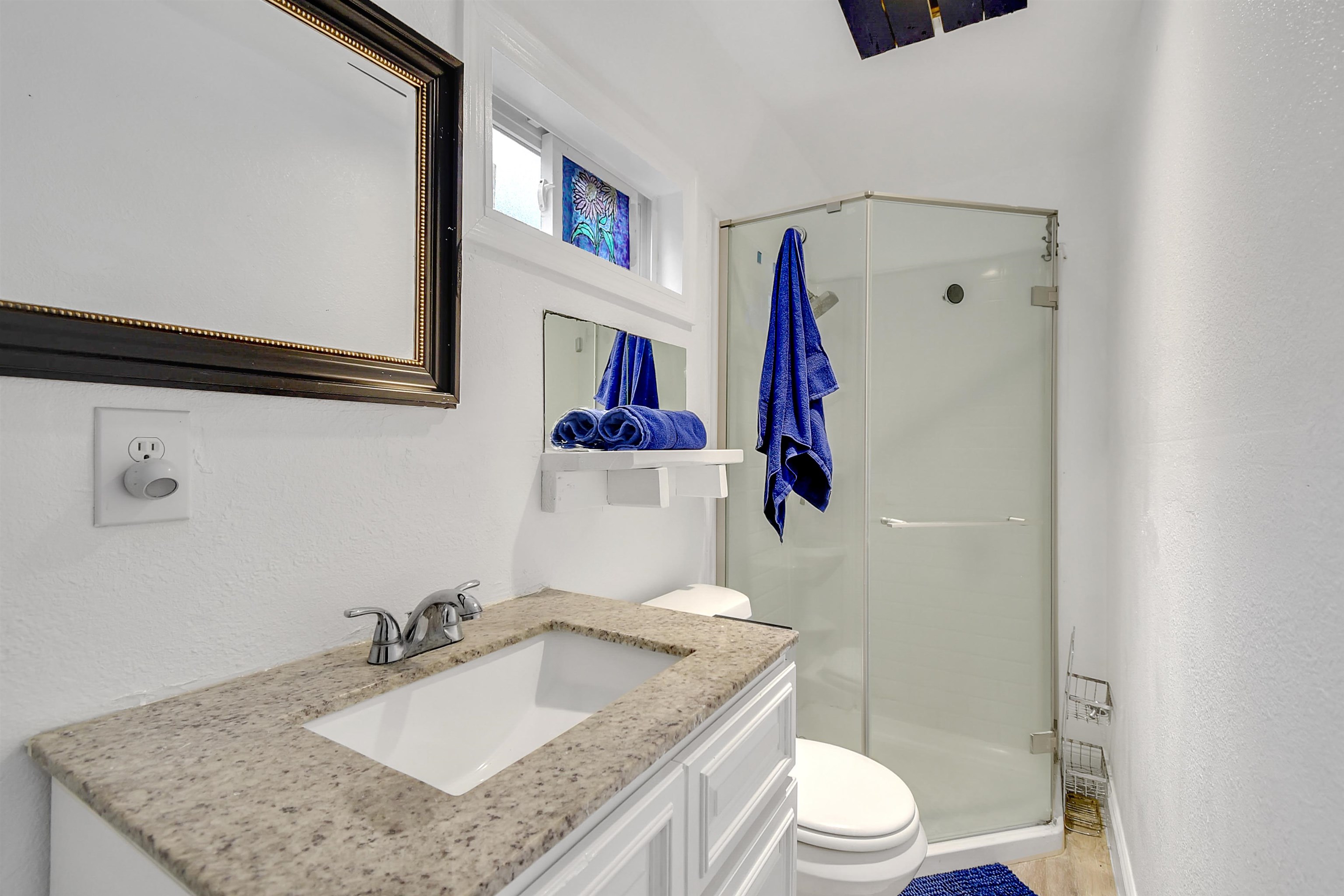 4895 Ave D, Unit B St. Augustine, FL 32095 - Photo 17 of 22 a bathroom with a granite countertop sink a toilet and a mirror