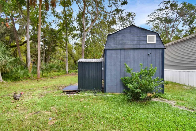 a view of a back yard with plants and wooden fence