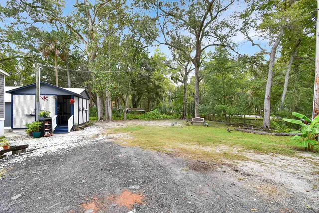 a view of a house with backyard and trees