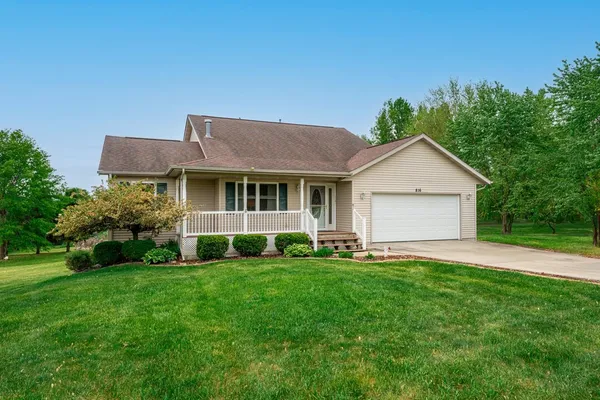 a front view of a house with a yard and trees