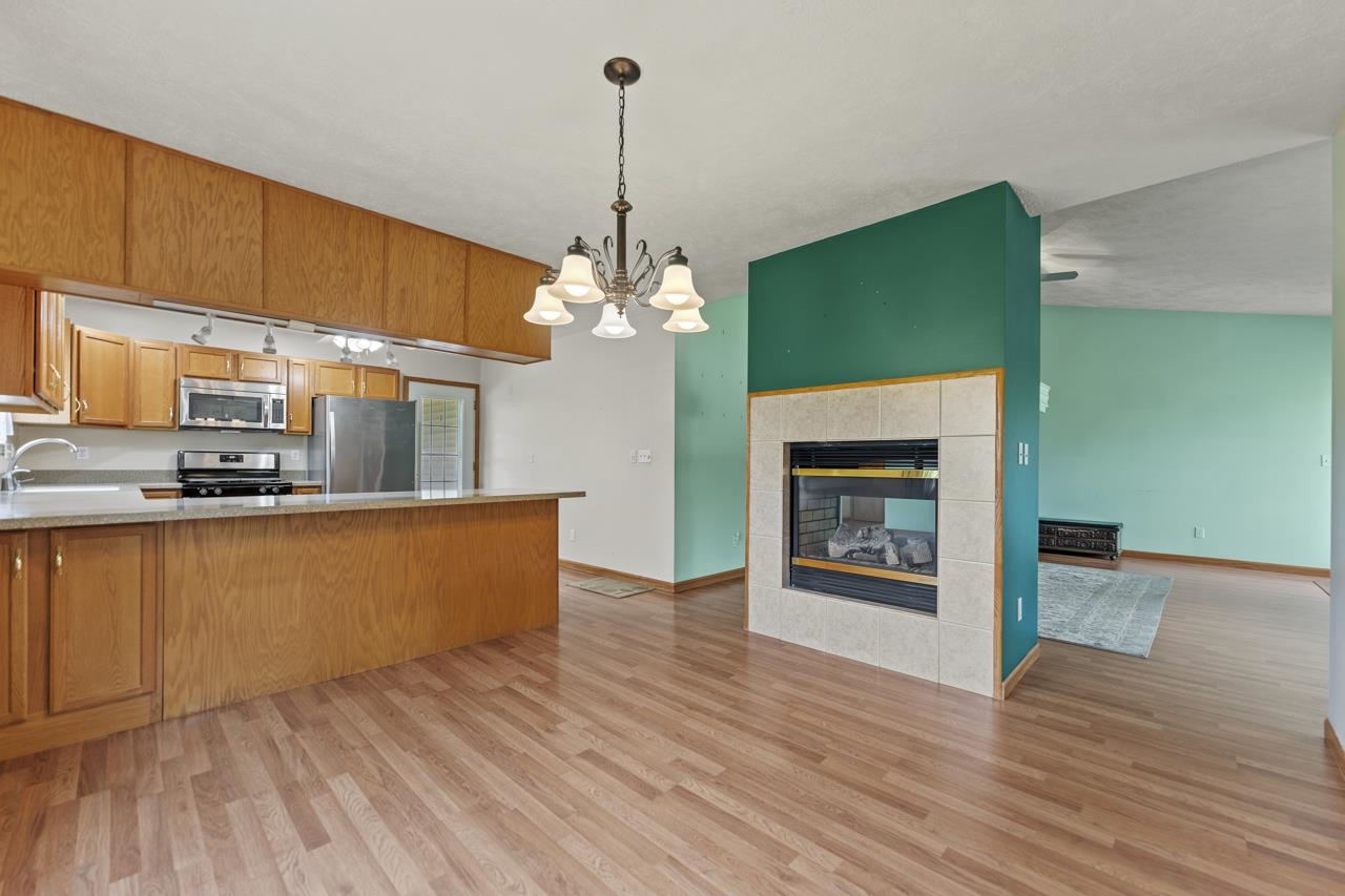 816 Lake Summerset Road Lake Summerset, IL 61019 - Photo 11 of 29 a kitchen with stainless steel appliances granite countertop a fireplace a sink dishwasher and a wooden floor