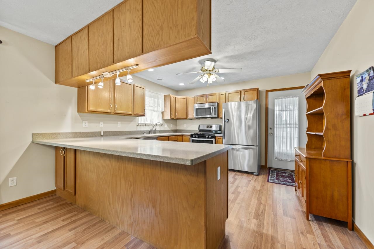 816 Lake Summerset Road Lake Summerset, IL 61019 - Photo 12 of 29 a kitchen with stainless steel appliances granite countertop a refrigerator a sink dishwasher a stove and white countertops with wooden floor