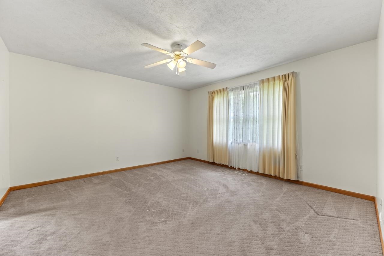 816 Lake Summerset Road Lake Summerset, IL 61019 - Photo 14 of 29 an empty room with chandelier fan and windows