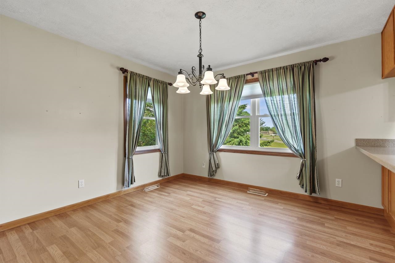 816 Lake Summerset Road Lake Summerset, IL 61019 - Photo 10 of 29 a view of a room with wooden floor large windows and a chandelier