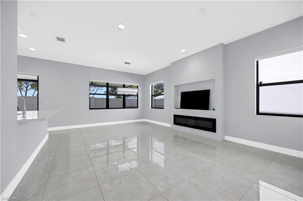 9045 Madrid Circle Naples, FL 34104 - Photo 12 of 46 a living room with furniture and a flat screen tv