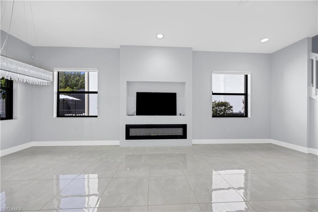 9045 Madrid Circle Naples, FL 34104 - Photo 13 of 46 a living room with furniture and a flat screen tv
