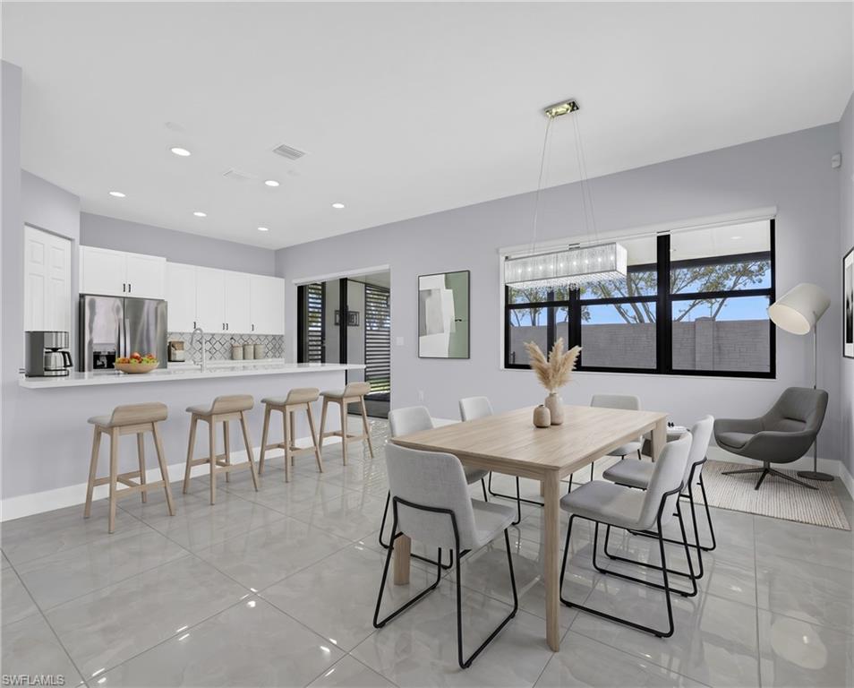 9045 Madrid Circle Naples, FL 34104 - Photo 14 of 46 Virtually Staged Spacious kitchen and dining area featuring light gray tile flooring, recessed lighting, and a contemporary linear chandelier