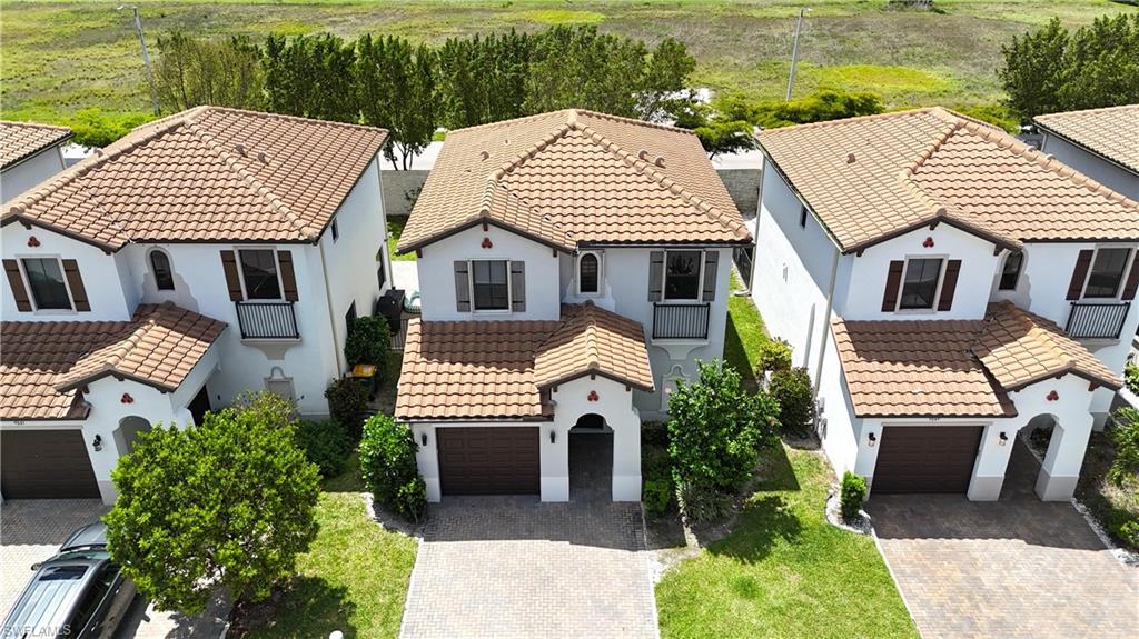9045 Madrid Circle Naples, FL 34104 - Photo 2 of 46 a front view of a house with a garden