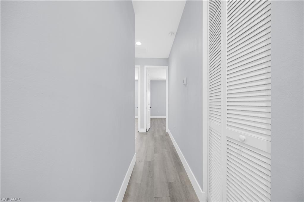 9045 Madrid Circle Naples, FL 34104 - Photo 21 of 46 a view of a hallway with wooden floor