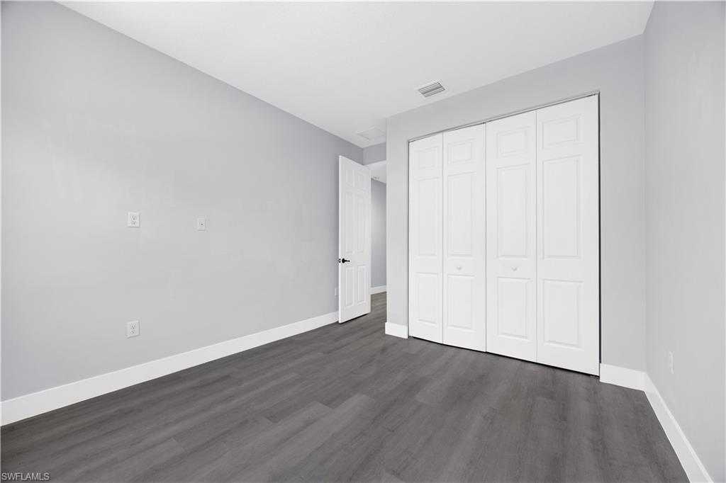9045 Madrid Circle Naples, FL 34104 - Photo 25 of 46 a view of an empty room with wooden floor