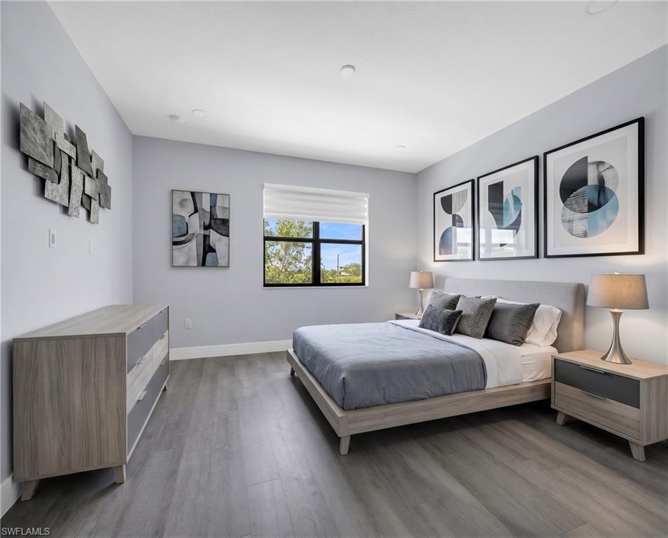 9045 Madrid Circle Naples, FL 34104 - Photo 26 of 46 Virtually Staged*Bedroom featuring wood-finish flooring, recessed ceiling lighting, a large window with roller shades, and a neutral color palette