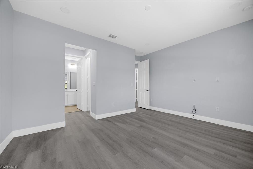 9045 Madrid Circle Naples, FL 34104 - Photo 27 of 46 a view of an empty room with wooden floor