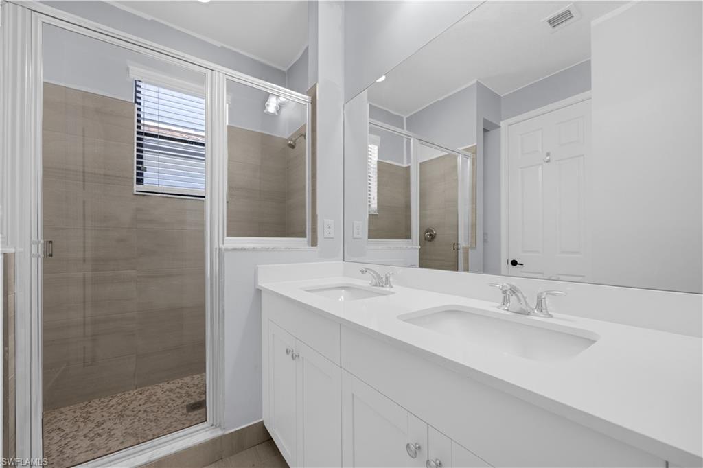 9045 Madrid Circle Naples, FL 34104 - Photo 32 of 46 a bathroom with a sink and a mirror