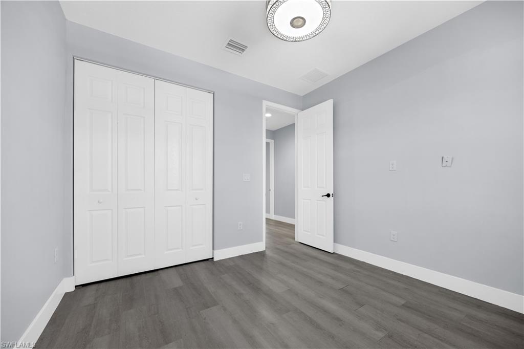 9045 Madrid Circle Naples, FL 34104 - Photo 37 of 46 a view of an empty room with wooden floor