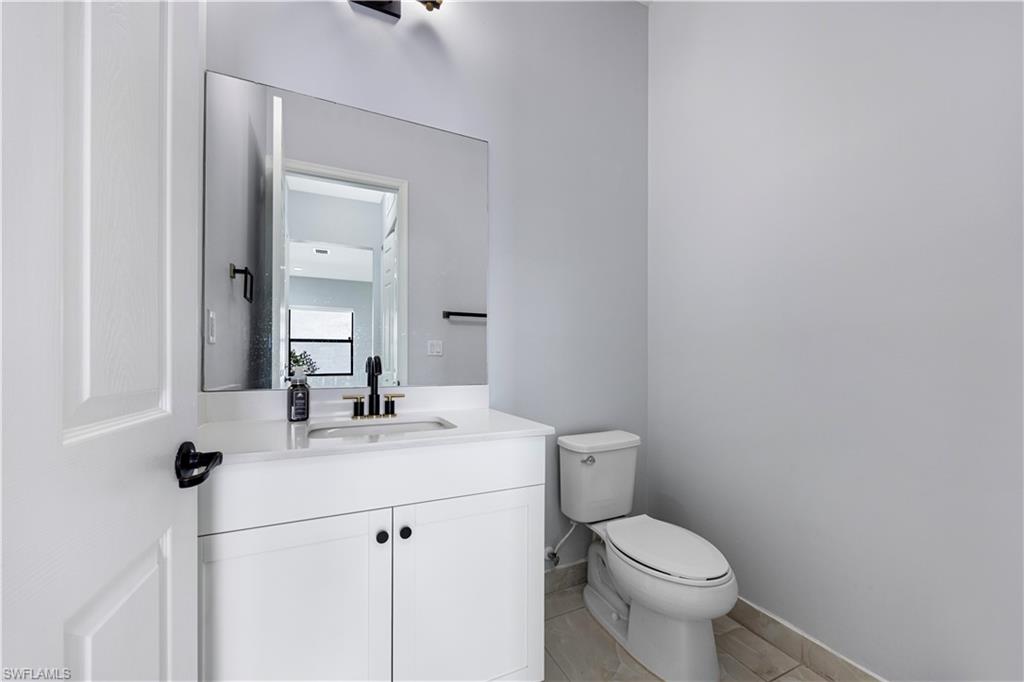 9045 Madrid Circle Naples, FL 34104 - Photo 38 of 46 a bathroom with a sink mirror vanity and toilet
