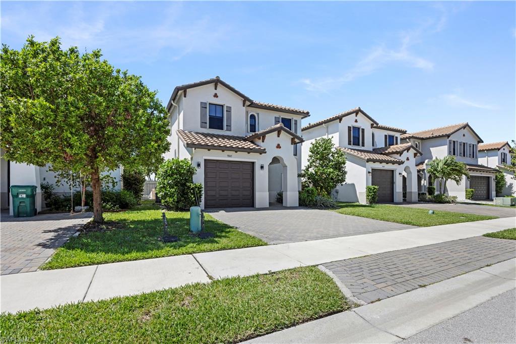 9045 Madrid Circle Naples, FL 34104 - Photo 6 of 46 a front view of a house with a yard and garage